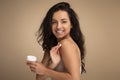 Happy beautiful young indian woman applying body cream on shoulder Royalty Free Stock Photo