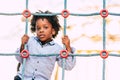 Happy and beautiful young kid black race african with ethnic alternative hair playing in a playground with coloured cords and have