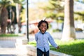 Happy and beautiful young kid black race african with ethnic alternative hair playing and runnig in a playground with and have