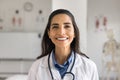 Happy beautiful young Latin doctor woman posing in clinic office