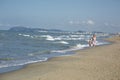 Happy beautiful young mom and child walking along the sea beach Royalty Free Stock Photo