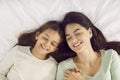 Happy beautiful young mother and her child sleeping on a comfortable bed together Royalty Free Stock Photo