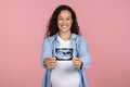 Happy young pregnant woman showing sonogram of her baby Royalty Free Stock Photo