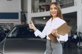 Happy beautiful young woman car dealer in showroom Royalty Free Stock Photo