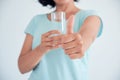 Happy beautiful young woman drinking water. Smiling caucasian female model holding transparent glass in her hand Royalty Free Stock Photo