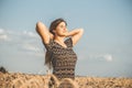 Happy beautiful young woman enjoying nature, raising hands on background of cloudy sky in wheat field, girl breathe breathes Royalty Free Stock Photo