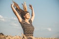 Happy beautiful young woman enjoying nature, raising hands on background of cloudy sky in wheat field, girl breathe breathes Royalty Free Stock Photo