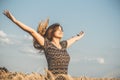 Happy beautiful young woman enjoying nature, raising hands on background of cloudy sky in wheat field, girl breathe breathes Royalty Free Stock Photo