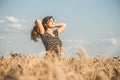 Happy beautiful young woman enjoying nature, raising hands on background of cloudy sky in wheat field, girl breathe breathes Royalty Free Stock Photo