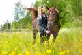 Happy woman feeding her arabian horse with snacks in the field Royalty Free Stock Photo