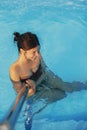 Happy Beautiful young woman having fun and smiling in pool, relaxing and enjoying summer holiday. Brunette girl on vacation in Royalty Free Stock Photo