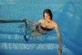 Happy Beautiful young woman having fun and smiling in pool, relaxing and enjoying summer holiday. Brunette girl on vacation in Royalty Free Stock Photo