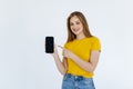 Happy beautiful young woman holding blank screen mobile phone and pointing finger over white background Royalty Free Stock Photo