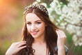 Happy beautiful young woman with long black healthy hair enjoy fresh flowers and sun light in blossom park at sunset. Royalty Free Stock Photo