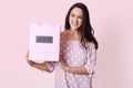 Happy beautiful young woman in polka dot dress, holding shopping bags in her hands and smiling happily. Studio shot of happy Royalty Free Stock Photo