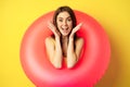 Happy beautiful young woman relaxing on summer vacation, wearing pink swim ring for beach holiday, standing against Royalty Free Stock Photo