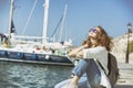 Happy beautiful young woman woman on sea and port background, tr Royalty Free Stock Photo