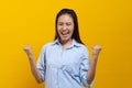 Happy beauty asian young woman showing excite expression. Shot in studio isolated on yellow background