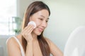 Happy beauty, beautiful asian young woman, girl smiling, looking in mirror, holding cotton pad, applying lotion by wipe on her Royalty Free Stock Photo