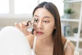 Happy beauty concept, asian young woman, girl make up face hand using eyelash curler on long eyelash before applying mascara brush Royalty Free Stock Photo