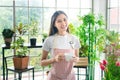 Happy beauty woman Portarit of positive cheerful floral entrepreneur concept wear apron beautiful flower plants indoors garden