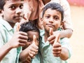 Happy best children friends boys classmates smiling showing thumb up gesture at the school. Multiethnic school kids enjoying