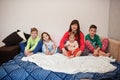 Happy big family is having fun together in bedroom. Large family morning concept. Mother with four kids wear pajamas in bed at Royalty Free Stock Photo