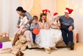 Happy big family portrait, celebrating new year or Christmas - parents and children in home interior decorated with holiday lights Royalty Free Stock Photo