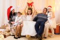 Happy big family portrait, celebrating new year or Christmas - parents and children in home interior decorated with holiday lights Royalty Free Stock Photo