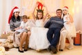 Happy big family portrait, celebrating new year or Christmas - parents and children in home interior decorated with holiday lights Royalty Free Stock Photo