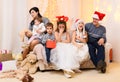 Happy big family portrait, celebrating new year or Christmas - parents and children in home interior decorated with holiday lights Royalty Free Stock Photo