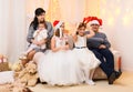 Happy big family portrait, celebrating new year or Christmas - parents and children in home interior decorated with holiday lights Royalty Free Stock Photo