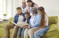 Happy family looking through their photo album while sitting on the couch at home Royalty Free Stock Photo