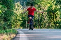 Happy biker cyclist riding his bike through the green woods