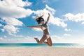 Happy bikini asian woman jumping of joy on beach. Tropical vacation travel destination.