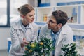 Biologists in white coats with lemon plants