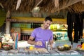 Happy biracial barman preparing cocktail at beach