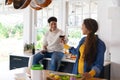 Happy biracial couple preparing food and drinking red wine in kitchen Royalty Free Stock Photo