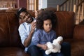 Happy biracial dad brush small daughter hair