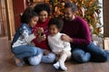 Happy biracial family with kids use cellphone at home Royalty Free Stock Photo