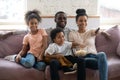 Happy biracial family with kids watch TV at home