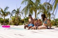 Happy biracial family sitting by swimming pool Royalty Free Stock Photo