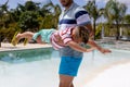 Happy biracial father and son playing by the swimming pool Royalty Free Stock Photo