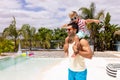 Happy biracial father and son playing by the swimming pool Royalty Free Stock Photo
