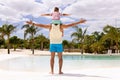 Happy biracial father and son widening arms by the swimming pool