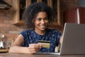 Happy biracial female buy goods at internet using gold card Royalty Free Stock Photo