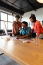 Happy biracial photographer discussing with multiracial colleagues in meeting at office Royalty Free Stock Photo