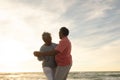 Happy biracial senior couple dancing romantically at beach against sky during sunset Royalty Free Stock Photo