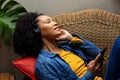 Happy biracial woman with headphones listening music using smartphone at home Royalty Free Stock Photo