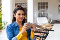 Happy biracial woman sitting on garden terrace drinking coffee outside house Royalty Free Stock Photo